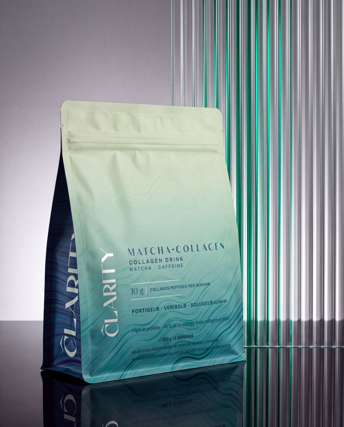 CLARITY Matcha-Collagen Standbeutel vor Glasstäben