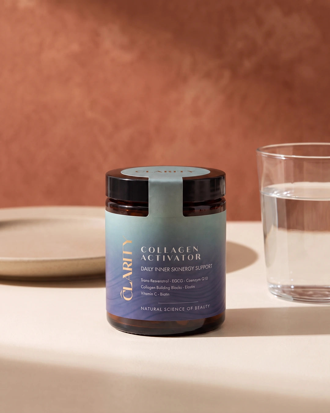 CLARITY Collagen Activator – Tiegel auf einem Tisch neben einem Glas Wasser